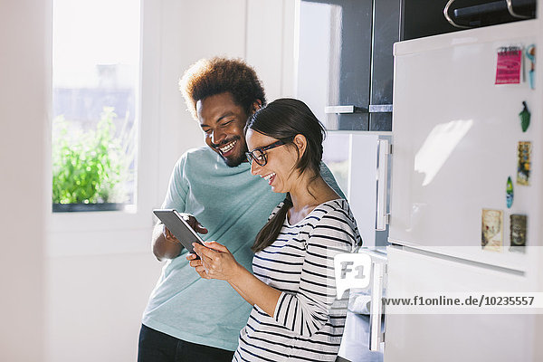 Happy young couple having fun in their kitchen