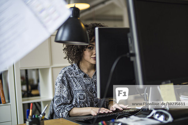 Junge Frau im Büro bei der Arbeit am Computer