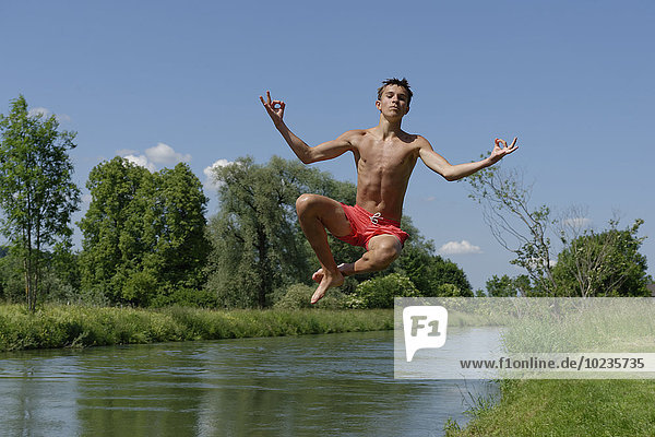 Germany  Bavaria  teenage boy jumping into River Loisach