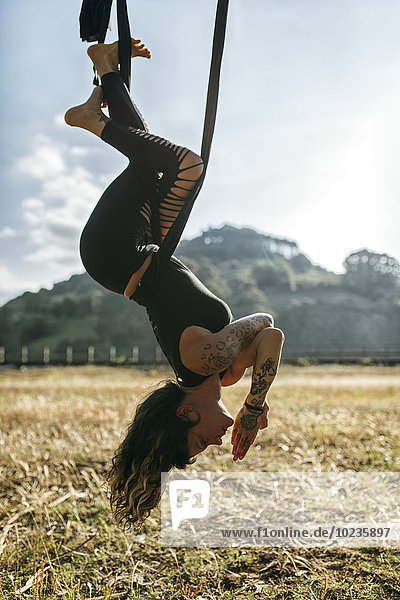 Spanien  Asturien  Villaviciosa  Frau beim Aerial Yoga im Freien