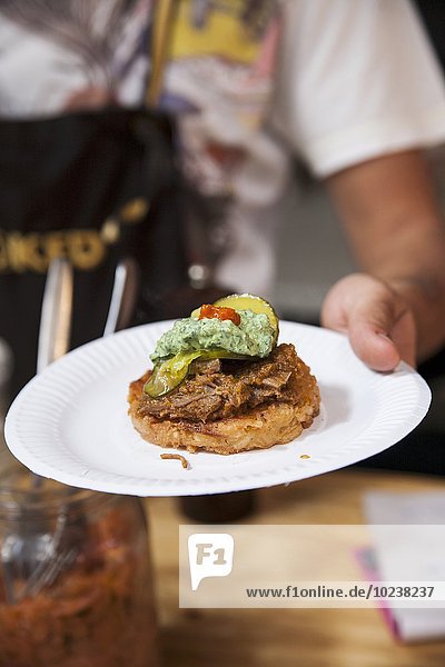 A waiter serving a roll with beef and guacamole
