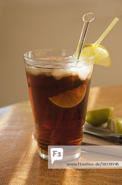Cola mit Rum  Limetten und Eiswürfeln im Sonnenlicht