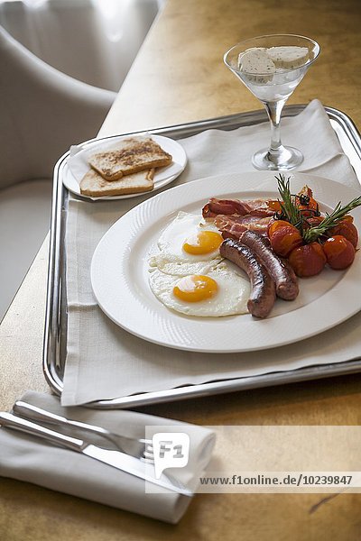 Herzhaftes Frühstück mit Spiegeleier  Würstchen  Speck und Toastbrot