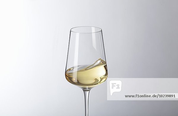 Schwappender Weisswein im Glas