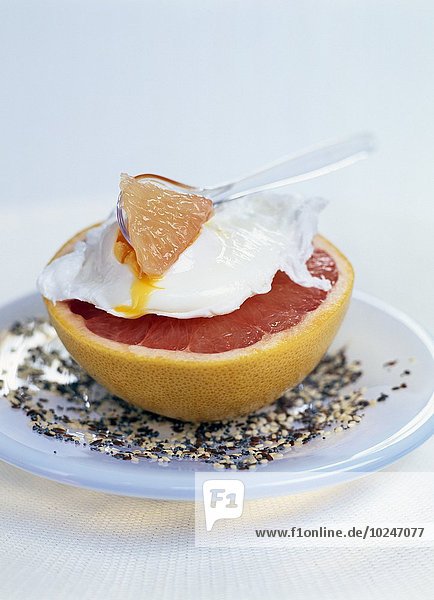 Half a pink grapefruit topped with a poached egg