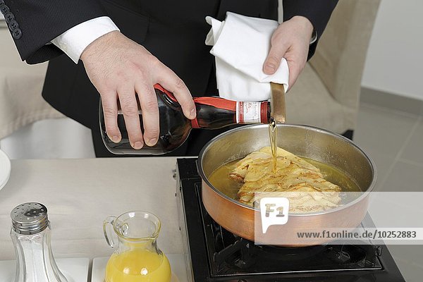 Preparing pancakes flambé