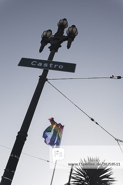 Tiefblick auf Castro-Straßenschild und Regenbogenfahne gegen klaren Himmel