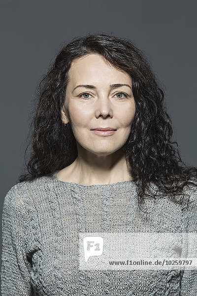 Porträt einer selbstbewussten reifen Frau über grauem Hintergrund