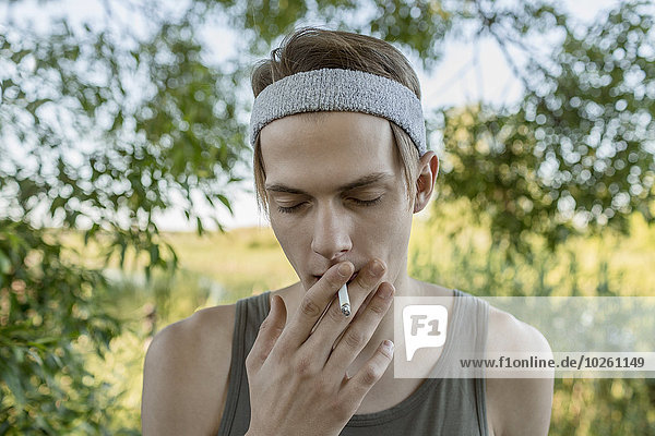 Young man smoking outdoors