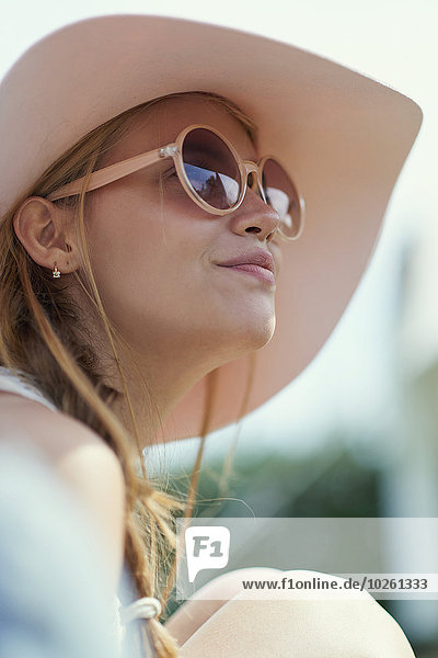 Low angle view of young woman wearing sunglasses and hat