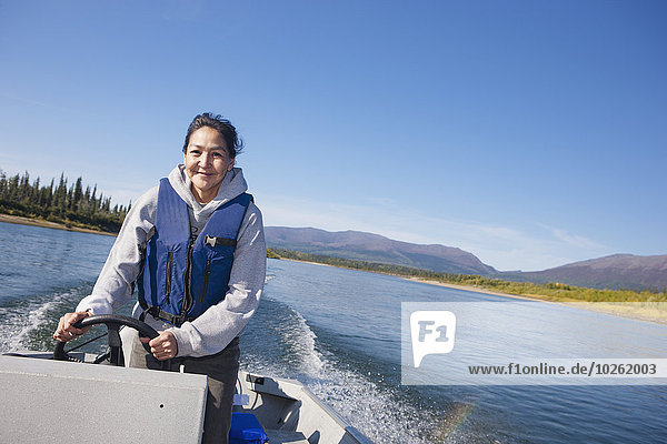 Alaskan Native female driving a motor boat on Kobuk river  Arctic Alaska  summer