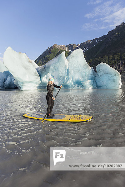 One woman stand up paddleboarding in front of Grewingk Glacier  Kachemak Bay State Park  Southcentral Alaska