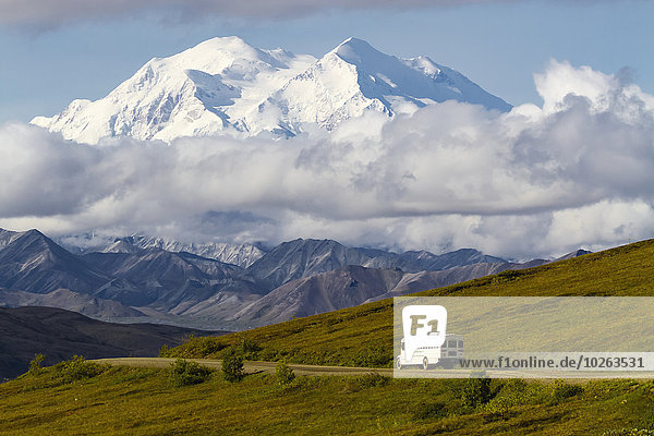 Scenic view of Mt. McKinley with the 'Denali Hybrid Bus' shuttle in the foreground in Denali National Park  Interior Alaska  Summer  USA.