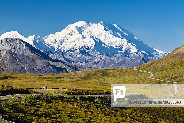 Scenic view of Mt. McKinley  Thorofare Pass  and Stony Dome in the foreground with a vehicle on the park road  Denali National Park  Interior Alaska