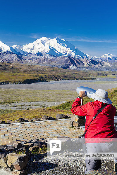 A male visitor views Mt. McKinley through the park provided scope at Eielson Visitor Center in Denali National Park  Interior Alaska  Summer  USA.