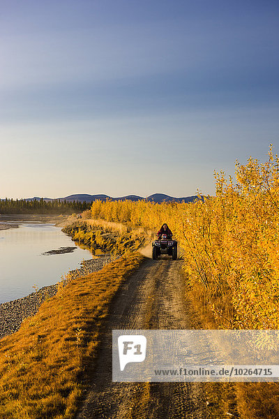 Vereinigte Staaten von Amerika USA Farbaufnahme Farbe Frau folgen Baum fahren Fluss vorwärts Menschenreihe Stacheldraht Quadbike Alaska Ethnisches Erscheinungsbild Noatak Alaska