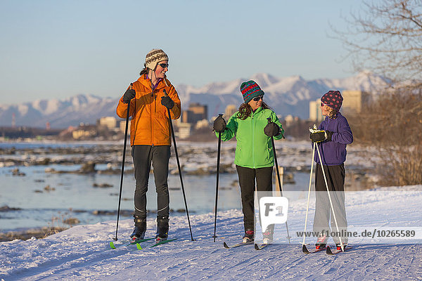 People cross country skiing on the Tony Knowles Coastal Trail near Earthquake Park with Anchorage skyline in the background  Cook Inlet  Southcentral Alaska