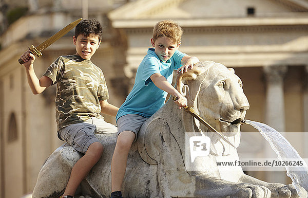 Portrait of two children on lion statue  Fontana dell'Obelisco  Piazza del Popolo (People's Square)  summer  Rome  Lazio  Italy