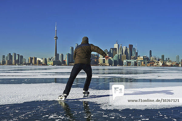Skater and city skyline from Ward's Island; Toronto  Ontario  Canada