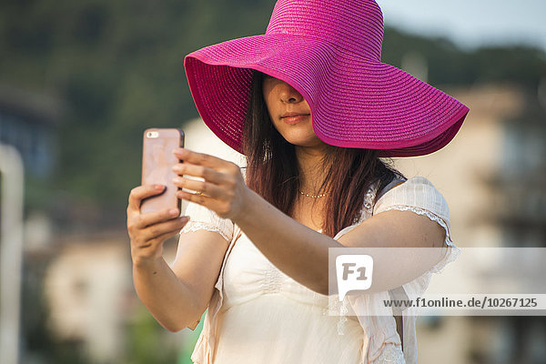 Handy junge Frau junge Frauen Portrait nehmen Hut pink groß großes großer große großen Einsamkeit China Fujian Xiamen