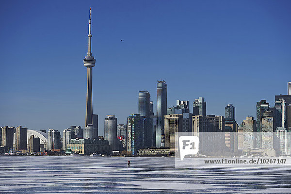 Skater against city skyline in winter; Toronto  Ontario  Canada