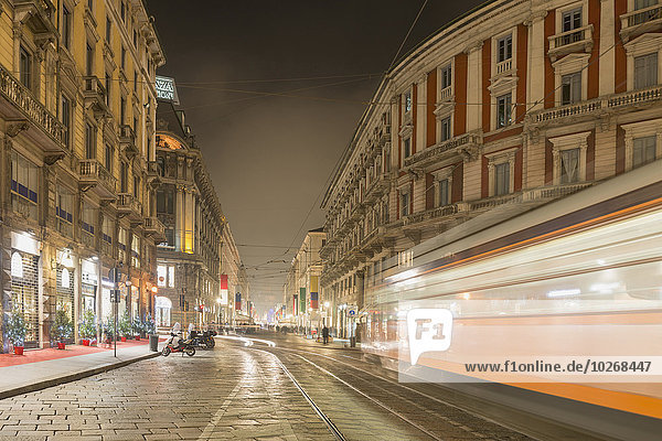 Motion blur of tram on street at nighttime; Milan  Lombardy  Italy