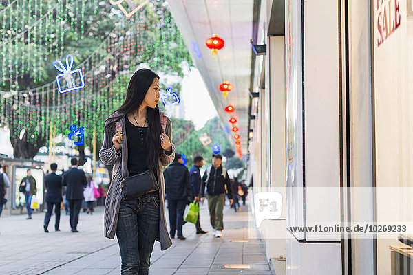 junge Frau junge Frauen Fenster Straße kaufen Handel Laden vorwärts China Hongkong