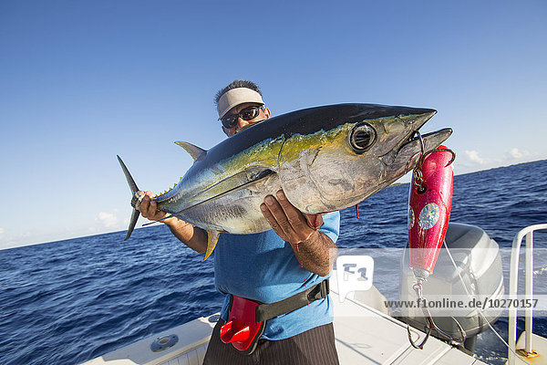 Fisherman posing with yellowfin tuna (Thunnus albacares); Tahiti