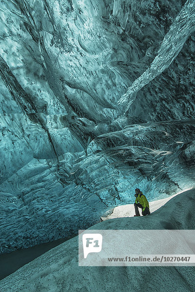 stehend Mütze Mensch unterhalb Eis Höhle groß großes großer große großen