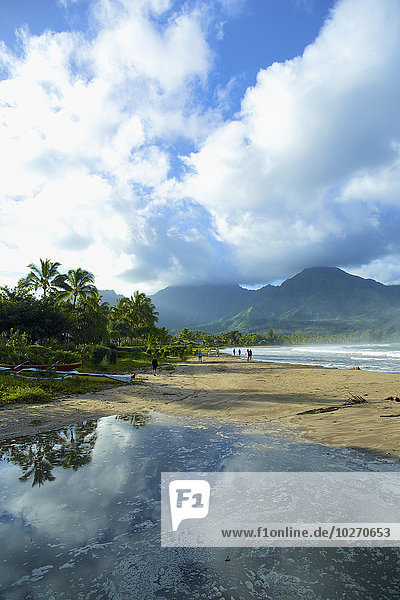 Tranquil water reflects rain clouds along the coast  Hanalei Bay; Kauai  Hawaii  United States of America
