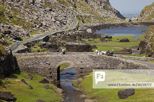 Fußgänger und Pferdekutschen auf einer Straße in der Gap of Dunloe  in der Nähe von Killarney; County Kerry  Irland