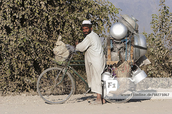 Paschtunischer Mann  der sein Restaurant auf einem Fahrrad auf der Straße von Torkham nach Jalalabad trägt  Provinz Nangarhar  Afghanistan