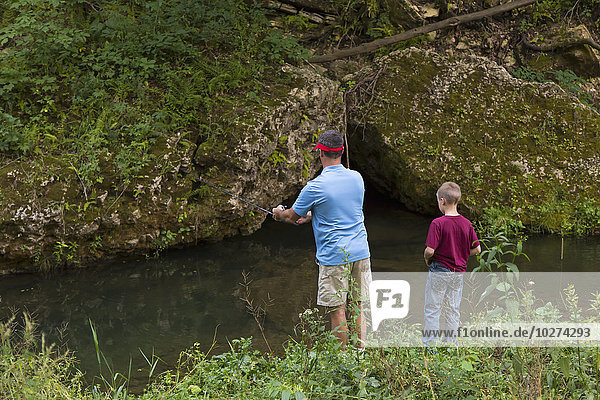 Vater und Sohn beim Angeln im Bear Creek im Bixby State Preserve  in der Nähe von Edgewood; Iowa  Vereinigte Staaten von Amerika'.