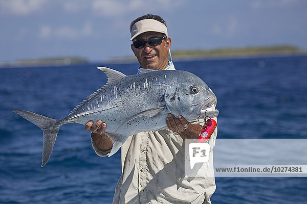 Fischer mit einem riesigen Trevally-Fisch (Caranx ignobilis); Tahiti'.