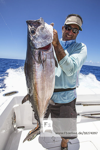 'Fisherman holding dogtooth tuna (Gymnosarda unicolor); Tahiti'
