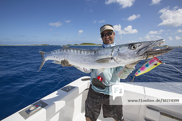 'Fisherman holding barracuda fish; Tahiti'