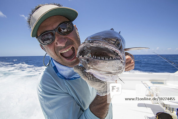 'Fisherman holding a fresh caught Dogtooth Tuna (Gymnosarda unicolor); Tahiti'