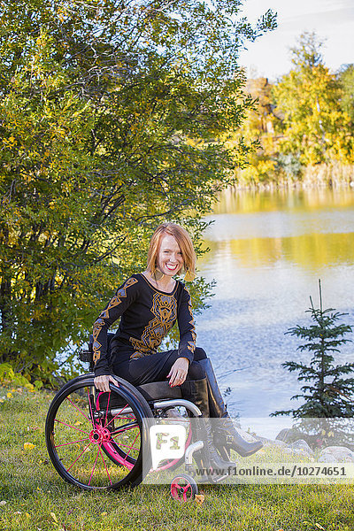 Porträt einer jungen behinderten Frau im Rollstuhl in einem Stadtpark im Herbst; Edmonton  Alberta  Kanada'.