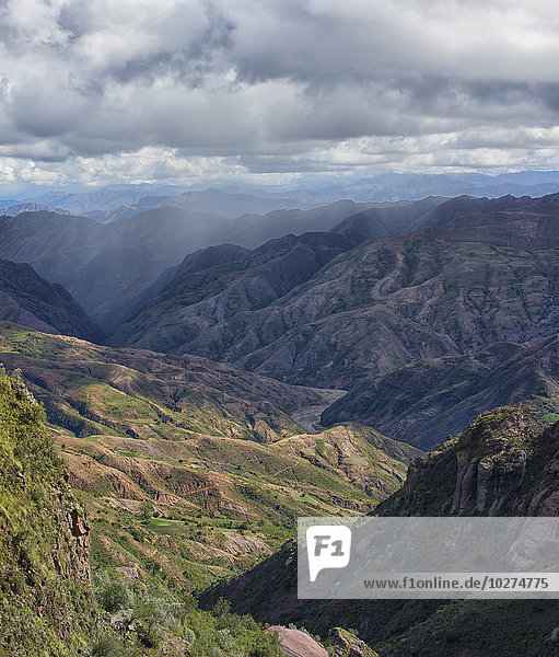 Die farbenfrohe Berglandschaft des Toro-Toro-Nationalparks mit einem Regenschauer in der Ferne; Bolivien'.