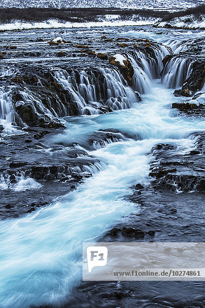 Türkisfarbenes Wasser  das über Felsen in einen Fluss fließt; Bruarfoss  Island'.