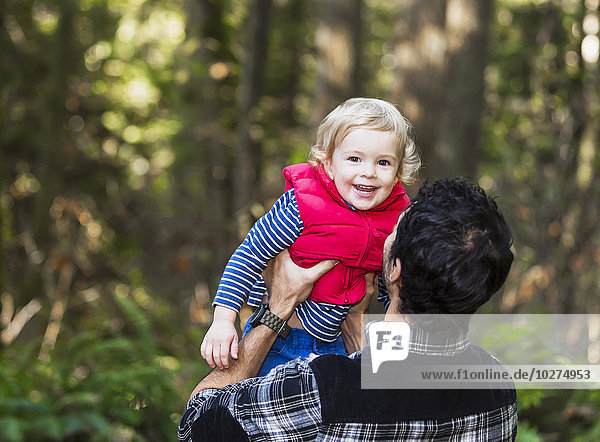 Vater hält seinen Sohn auf einem Pfad im Regenwald; Langley  British Columbia  Kanada'.