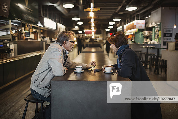 Seitenansicht des Seniorenpaares beim Kaffee in der Cafeteria