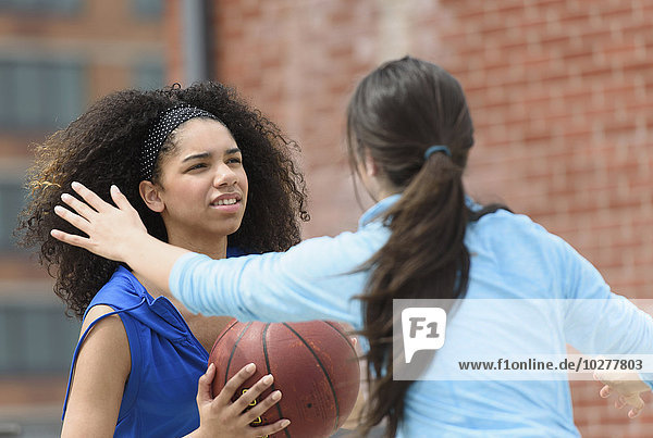 Mädchen im Teenageralter (14-15  16-17) spielen Basketball