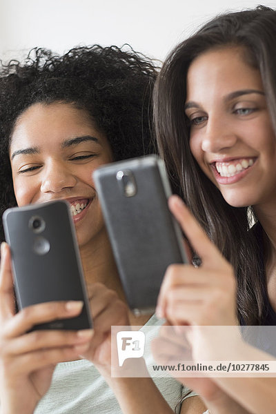 Mädchen im Teenageralter (14-15  16-17)  die Smartphones benutzen