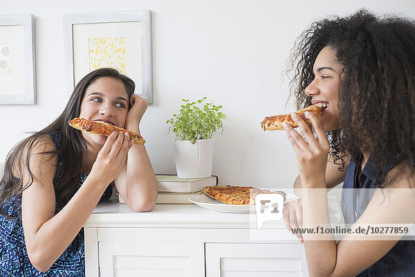 Teenage girls (14-15  16-17) eating pizza