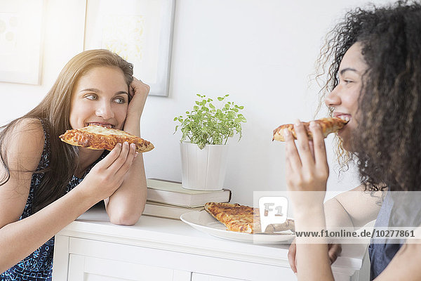 Mädchen im Teenageralter (14-15  16-17) beim Pizzaessen