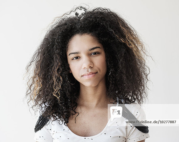 Porträt eines Mädchens im Teenageralter (16-17) auf weißem Hintergrund
