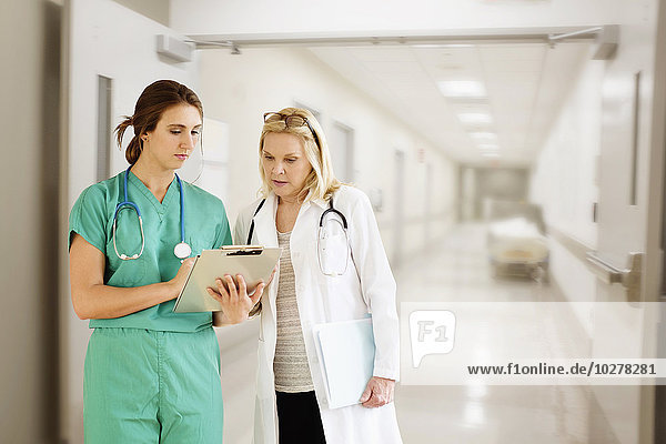 Two female doctors looking at medical documents