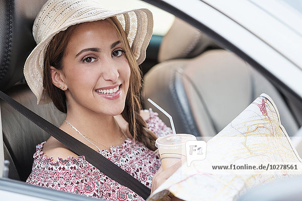 Lächelnde Frau mit Karte im Auto