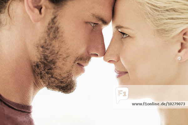 Couple rubbing noses on white background